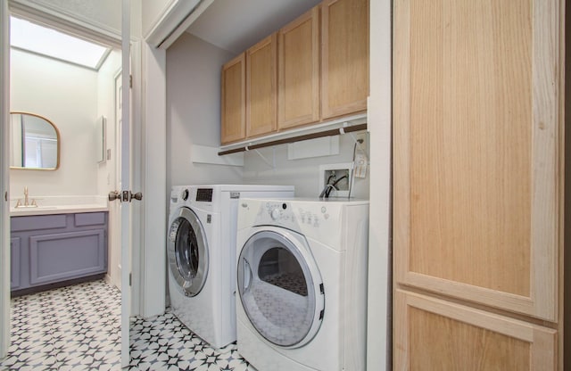 laundry area featuring cabinets, washing machine and dryer, and sink