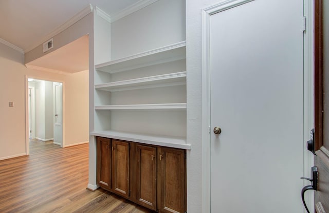 hallway with crown molding and light hardwood / wood-style floors