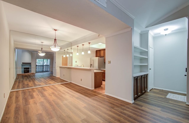 kitchen with stainless steel refrigerator with ice dispenser, dark wood-type flooring, crown molding, pendant lighting, and built in features