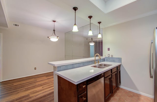 kitchen with sink, stainless steel appliances, kitchen peninsula, crown molding, and decorative light fixtures