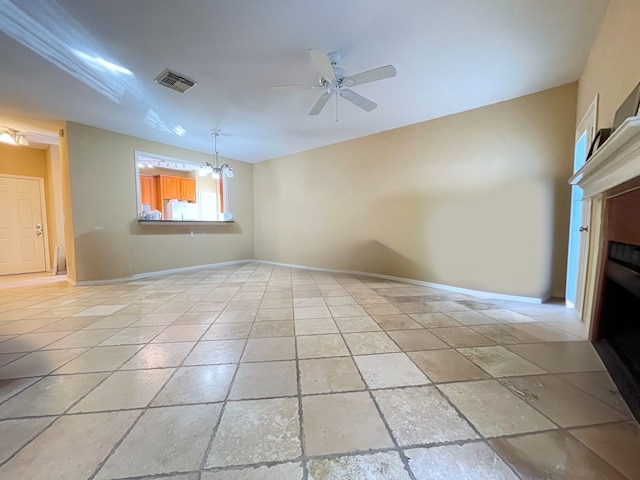 spare room with ceiling fan with notable chandelier