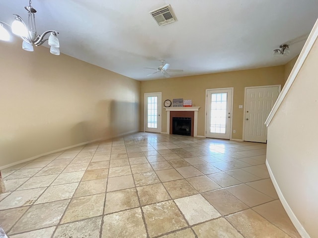 unfurnished living room featuring ceiling fan with notable chandelier