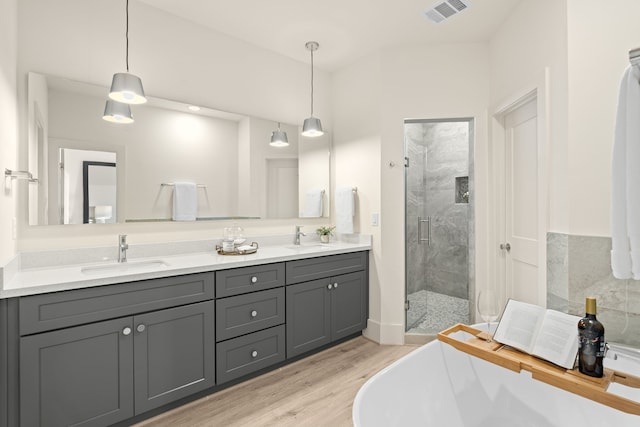 bathroom with vanity, wood-type flooring, and independent shower and bath