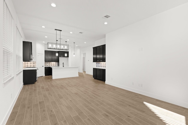 unfurnished living room featuring light wood-style floors, baseboards, visible vents, and recessed lighting