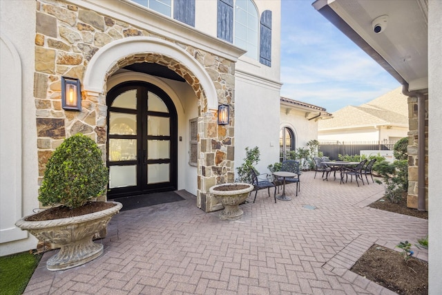 property entrance with a patio area and french doors