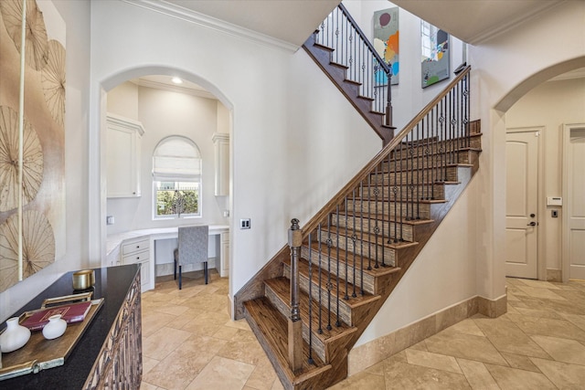 stairs featuring crown molding and built in desk