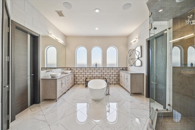 bathroom featuring vanity, separate shower and tub, and tile walls