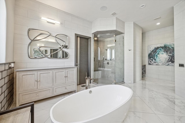 bathroom with vanity, separate shower and tub, and tile walls