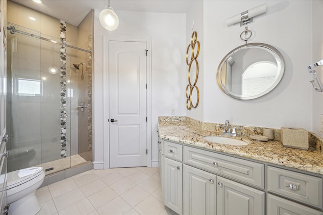 bathroom with vanity, a shower with shower door, tile patterned floors, and toilet