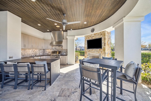 view of patio / terrace with exterior kitchen, a grill, a wet bar, and ceiling fan