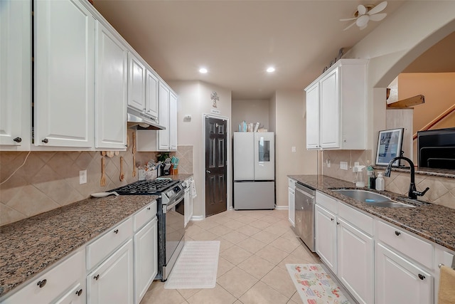 kitchen with sink, white cabinetry, stainless steel appliances, and stone counters