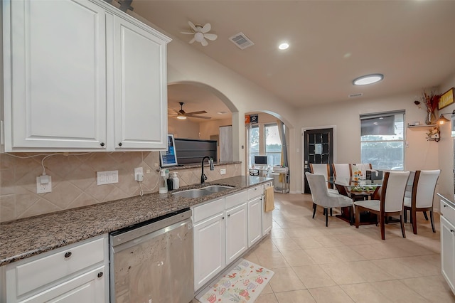 kitchen featuring dishwasher, dark stone counters, sink, ceiling fan, and white cabinetry