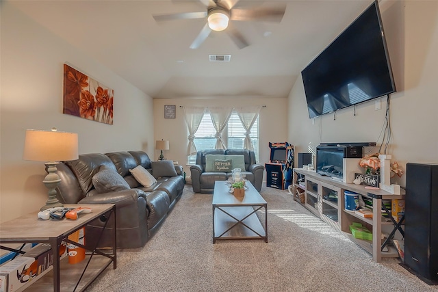 carpeted living room with ceiling fan and vaulted ceiling