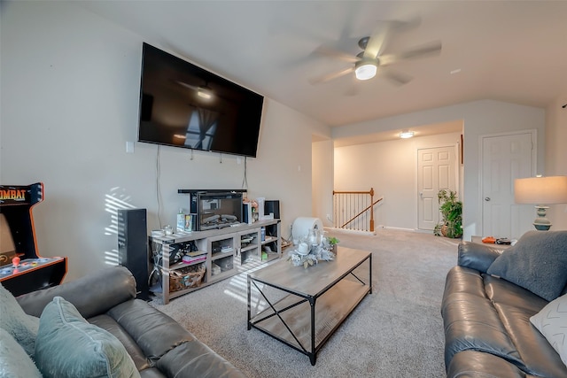 living room with ceiling fan, carpet floors, and lofted ceiling