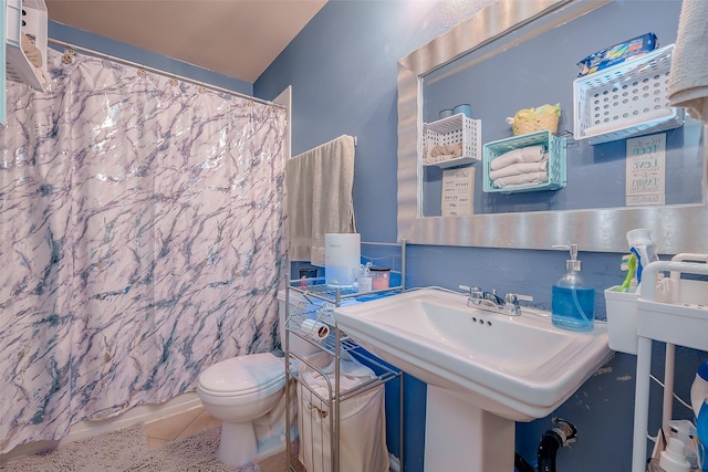 bathroom featuring tile patterned floors, a shower with curtain, sink, and toilet