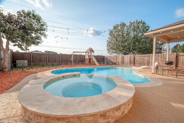 view of swimming pool with an in ground hot tub and a playground