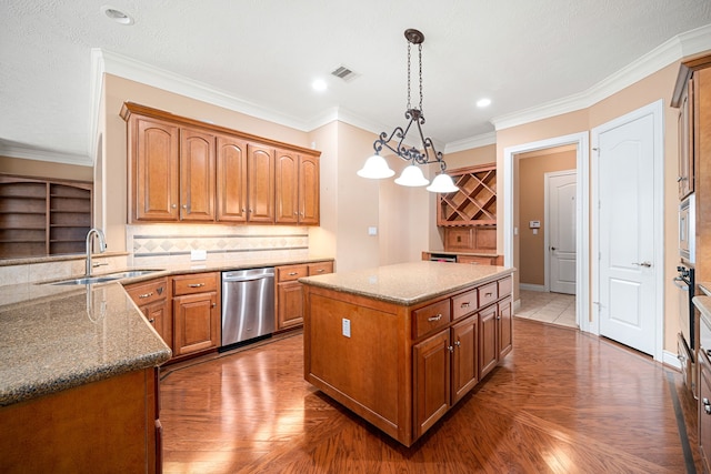 kitchen with pendant lighting, sink, appliances with stainless steel finishes, ornamental molding, and a kitchen island