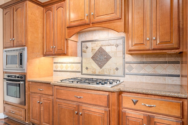 kitchen featuring tasteful backsplash, stainless steel appliances, and light stone counters