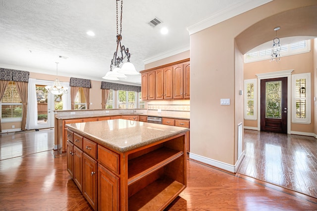 kitchen with a chandelier, dishwasher, sink, and a kitchen island