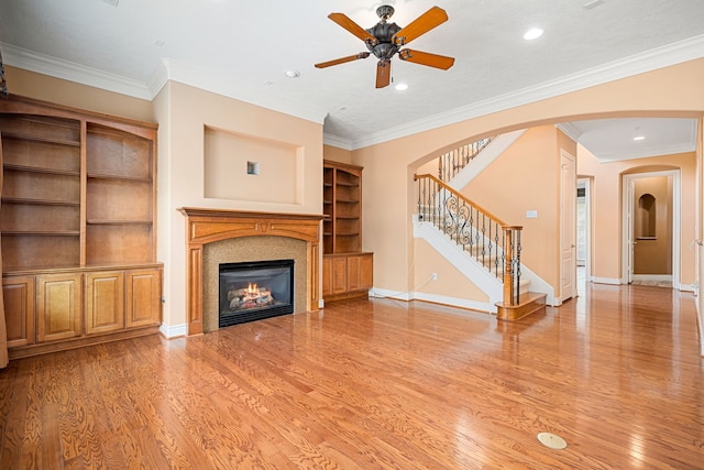 unfurnished living room with ceiling fan, ornamental molding, and wood-type flooring