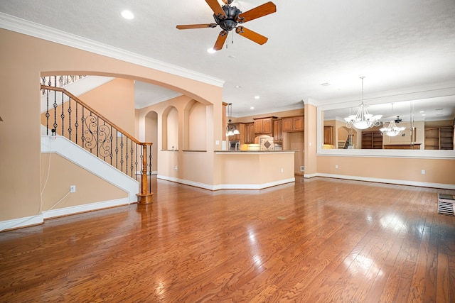 unfurnished living room with ornamental molding, dark hardwood / wood-style floors, and ceiling fan with notable chandelier