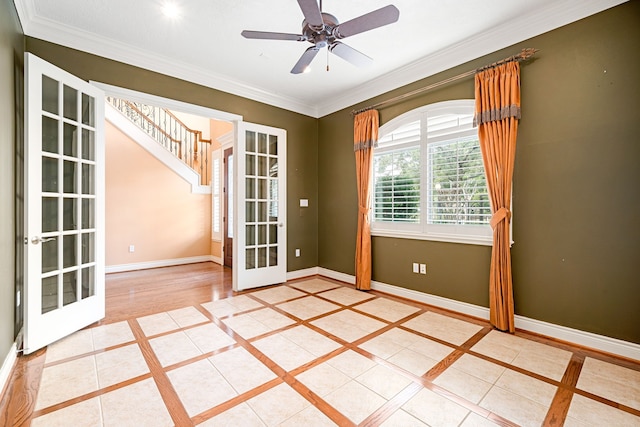 tiled empty room with crown molding, french doors, and ceiling fan