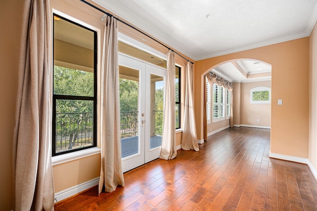 entryway with hardwood / wood-style floors, a raised ceiling, crown molding, a textured ceiling, and french doors