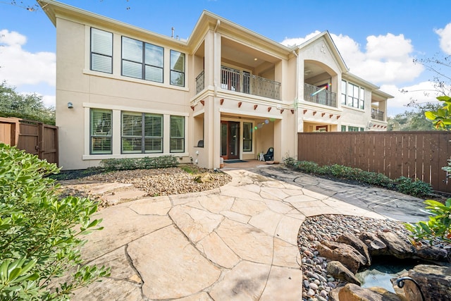 rear view of property with a balcony and a patio