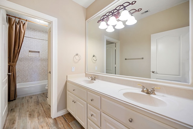 full bathroom featuring vanity, hardwood / wood-style flooring, toilet, and tiled shower / bath combo