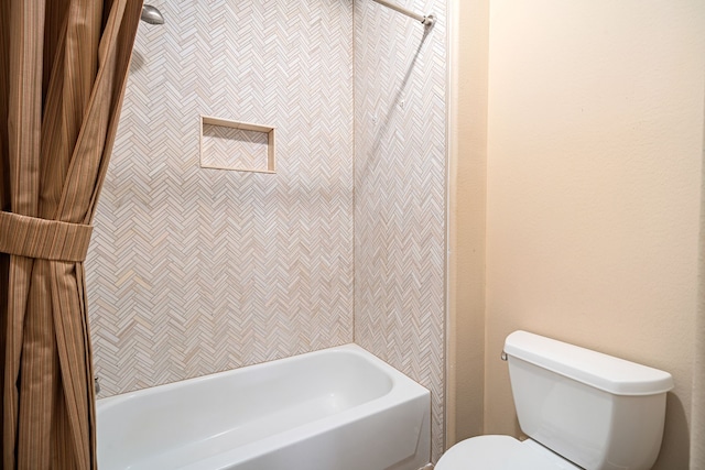 bathroom featuring tiled shower / bath and toilet