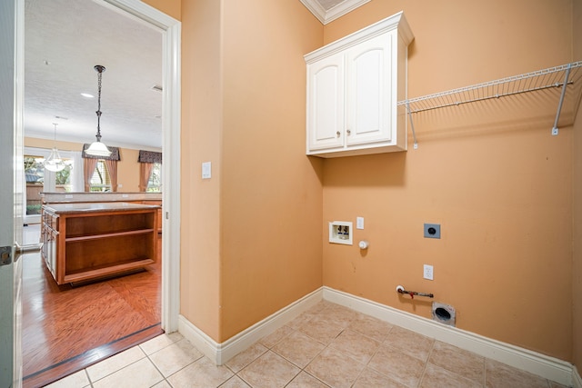 clothes washing area with gas dryer hookup, light tile patterned flooring, cabinets, hookup for a washing machine, and electric dryer hookup