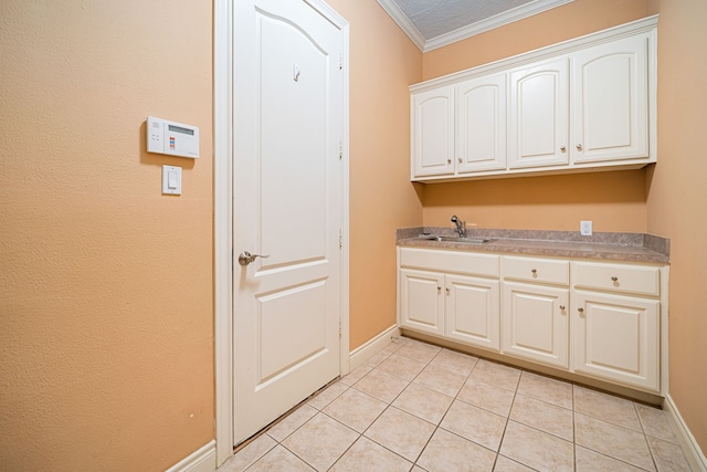 laundry room with crown molding, light tile patterned flooring, and sink