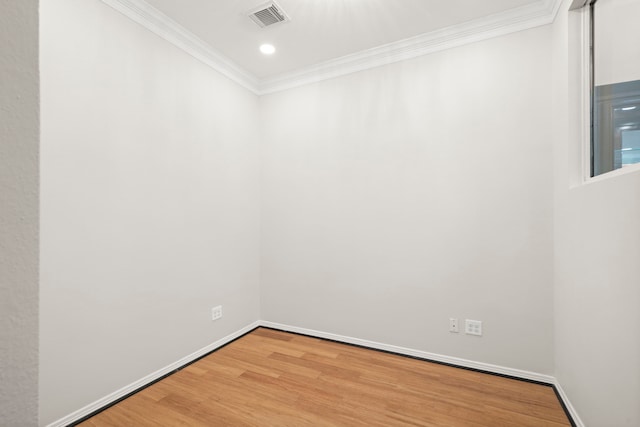 spare room featuring hardwood / wood-style flooring and ornamental molding