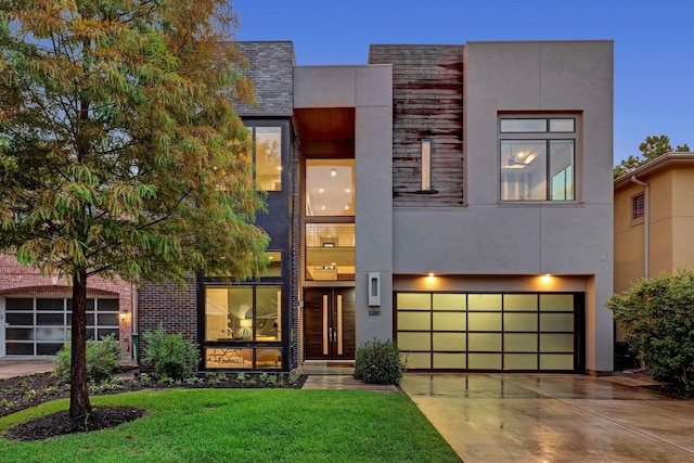 contemporary house with a garage and a front lawn