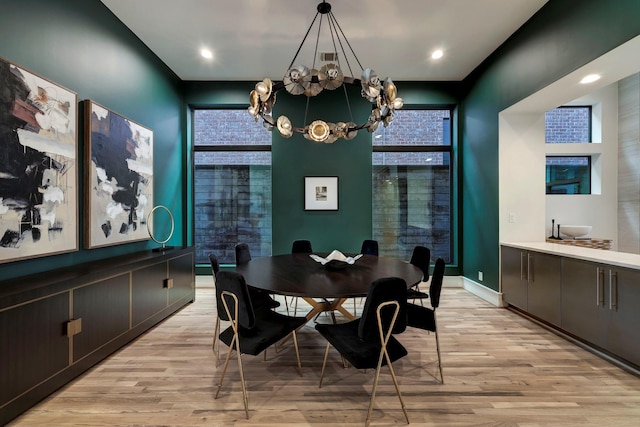 dining space with light wood-type flooring and a chandelier