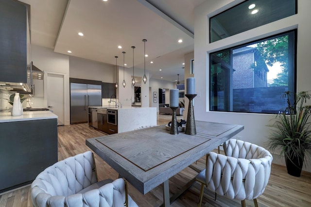 dining room with sink and light wood-type flooring