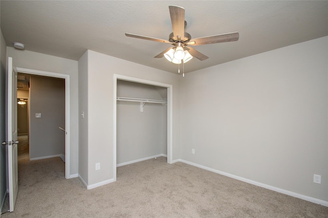 unfurnished bedroom featuring ceiling fan, a closet, and light carpet