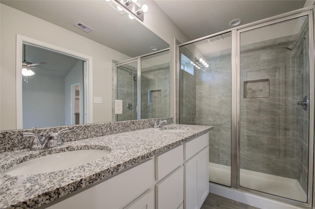 bathroom with ceiling fan, a shower with door, and vanity