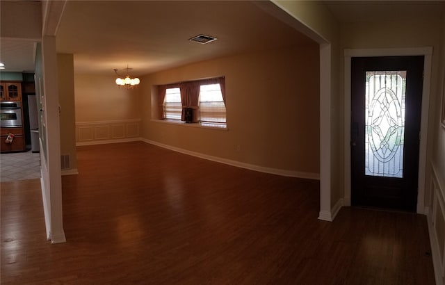 entryway with dark hardwood / wood-style floors and a notable chandelier