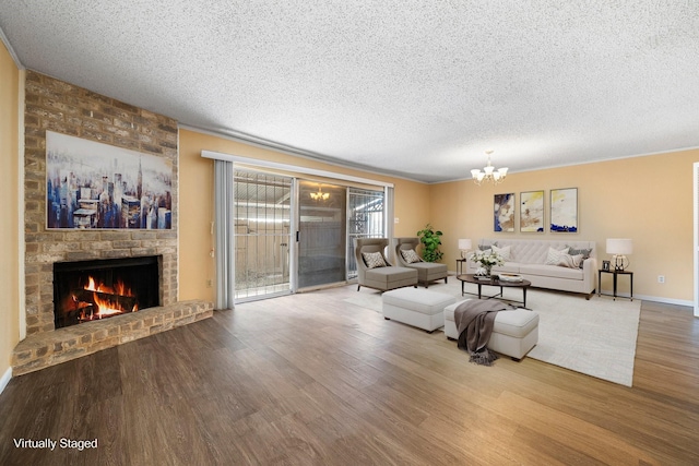 living room with hardwood / wood-style flooring, a fireplace, a textured ceiling, and an inviting chandelier