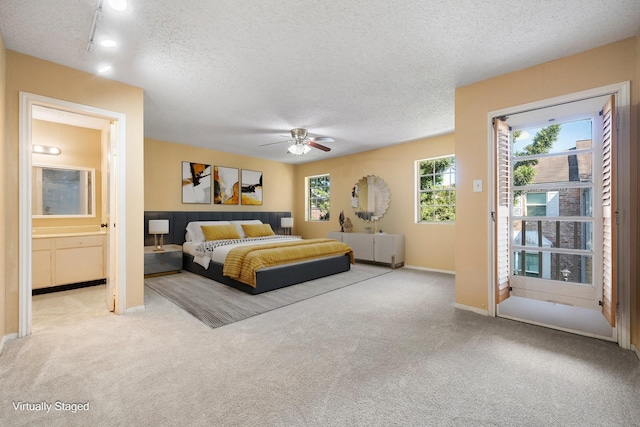 carpeted bedroom featuring ceiling fan, a textured ceiling, and connected bathroom