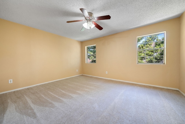 carpeted spare room with a textured ceiling and ceiling fan