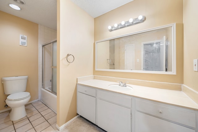 full bathroom featuring bath / shower combo with glass door, a textured ceiling, vanity, tile patterned flooring, and toilet