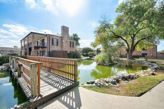 dock area featuring a balcony and a water view