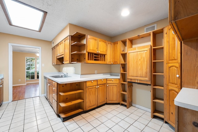 kitchen with a textured ceiling, ceiling fan, light tile patterned flooring, and sink