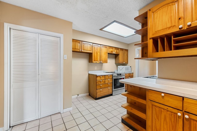 kitchen with a textured ceiling, stainless steel electric range oven, and light tile patterned flooring