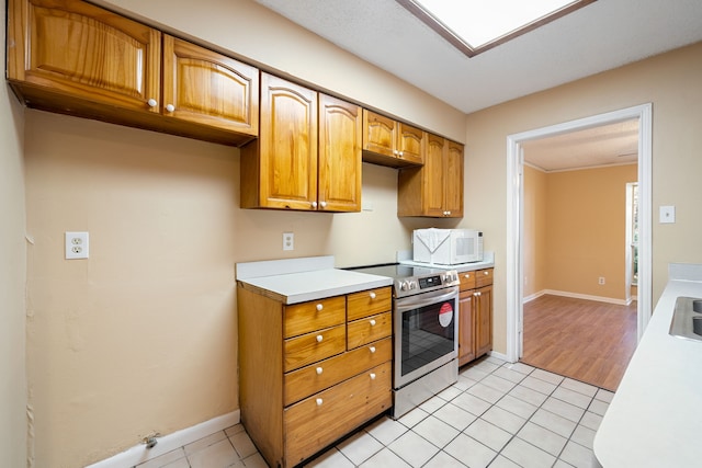 kitchen featuring stainless steel electric range oven and light tile patterned floors