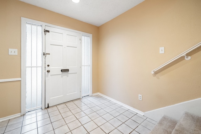 foyer featuring light tile patterned flooring and a textured ceiling