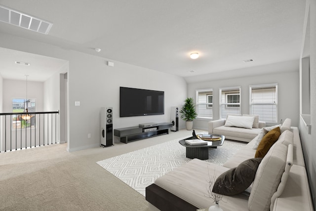 carpeted living room featuring visible vents, baseboards, a notable chandelier, and a healthy amount of sunlight
