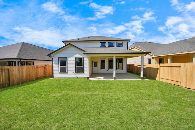 rear view of property featuring a fenced backyard, a yard, and a patio area